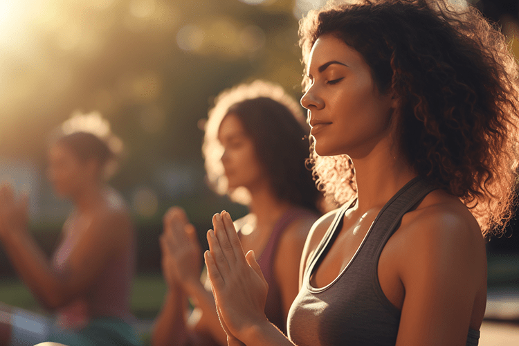 Three people doing yoga together outside