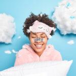 Transform Your Sleep with Tiny Habits A woman smiling while sleeping and dreaming in the clouds