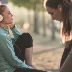 Two women getting to run, one is listening to music with headphones